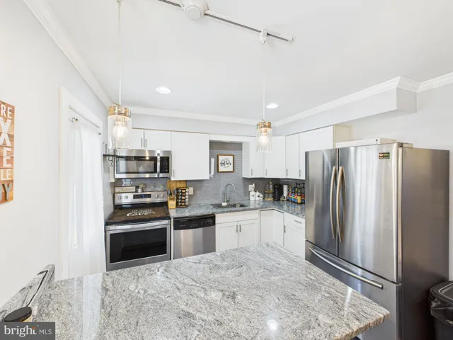 a kitchen with stainless steel appliances granite countertop a refrigerator and a sink