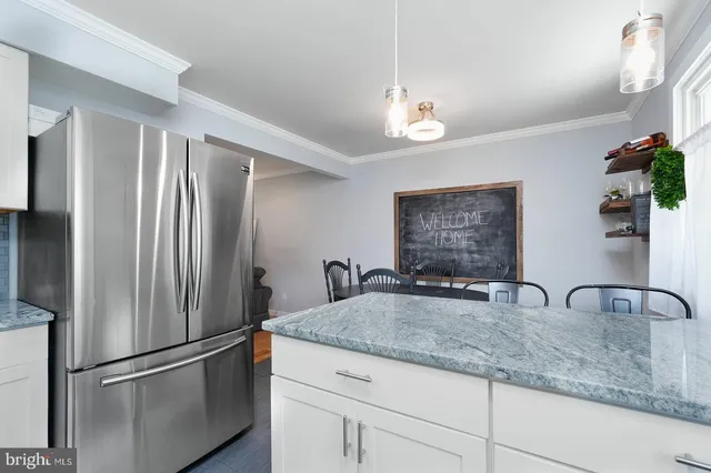 a kitchen with granite countertop a refrigerator and a sink