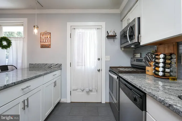 a kitchen with stainless steel appliances granite countertop a sink stove and cabinets