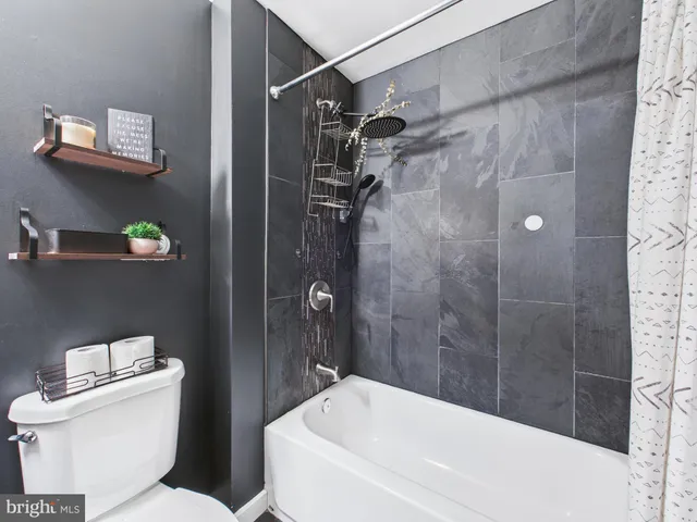 a bedroom with a bed a flat screen tv and a dresser