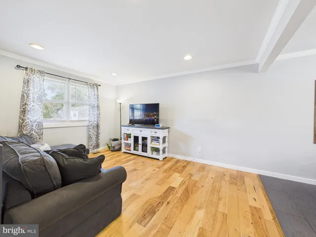 a living room with furniture a flat screen tv and a window