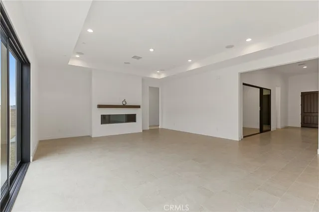 an empty room with a fireplace and cabinet