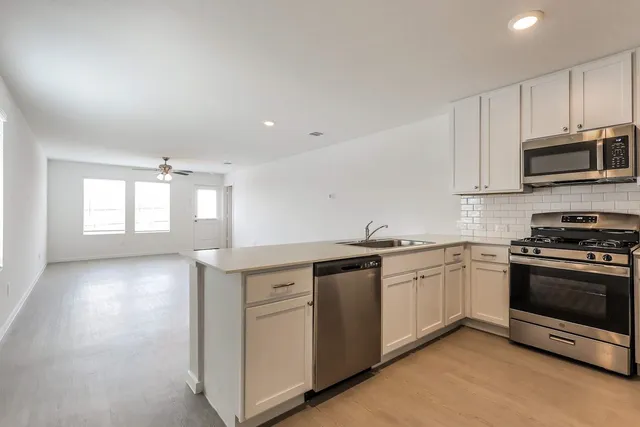 a kitchen with appliances a sink and cabinets