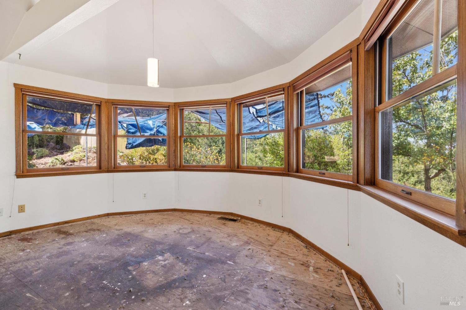 21540 Siri Road Guerneville, CA 95446 - Photo 19 of 99 an empty room with wooden floor and windows