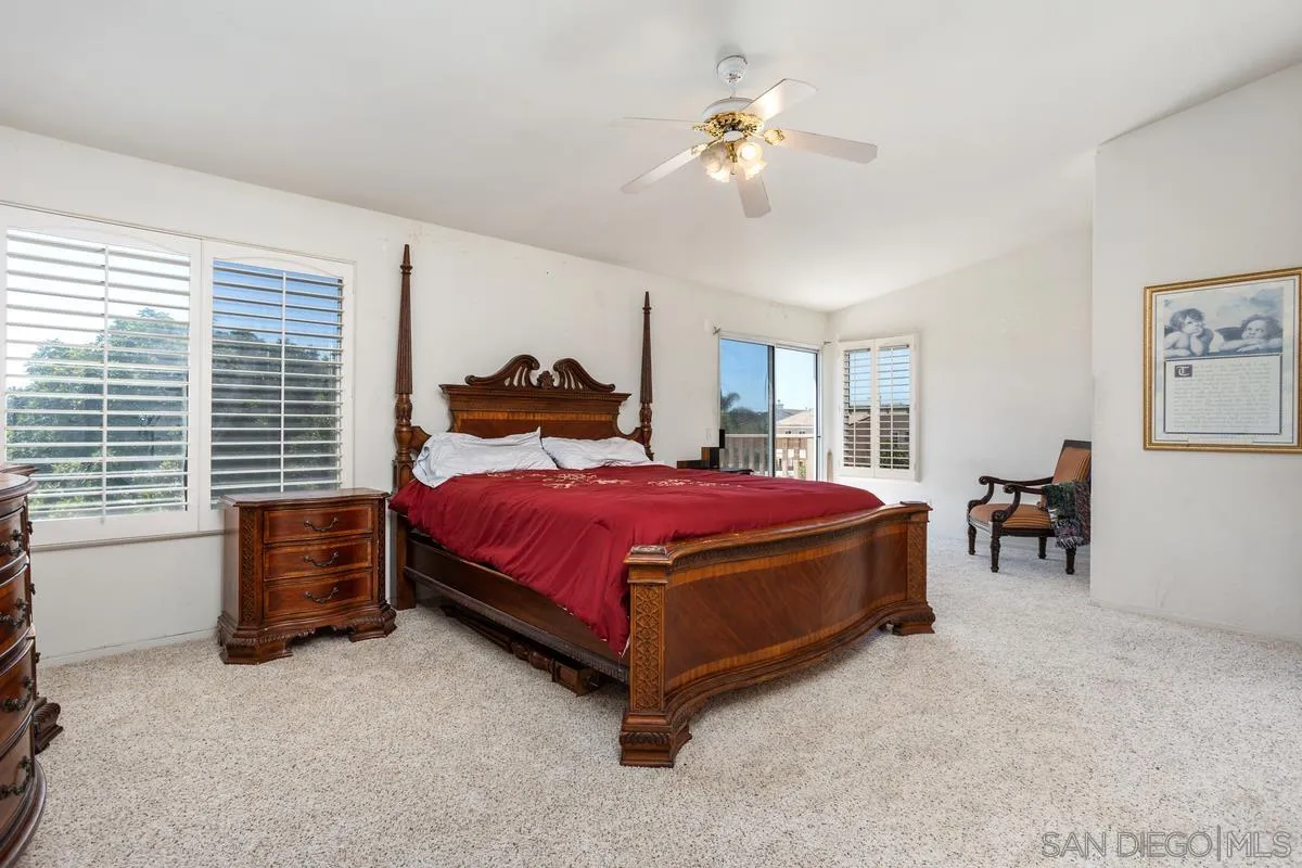 408 Shadow Tree Drive Oceanside, CA 92058 - Photo 13 of 29 a spacious bedroom with a bed and a chandelier