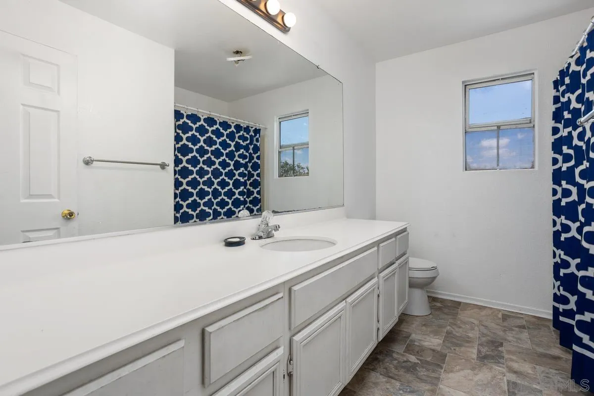 408 Shadow Tree Drive Oceanside, CA 92058 - Photo 19 of 29 a bathroom with a sink a double vanity and a shower
