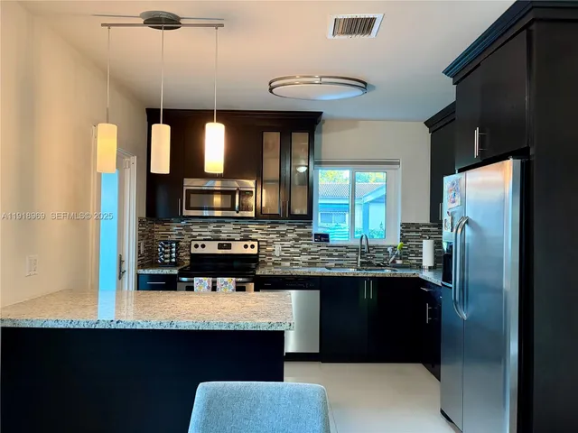 a kitchen with a sink a microwave a stove and refrigerator