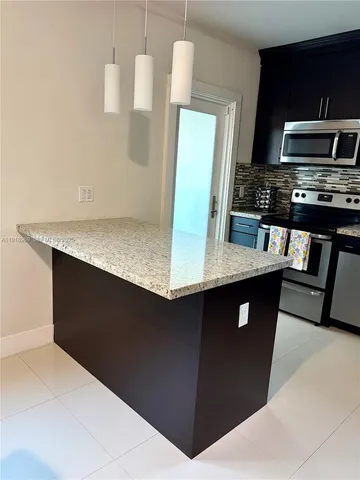 a kitchen with stainless steel appliances granite countertop a refrigerator and a stove