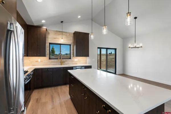 a kitchen with a sink a large window and wooden cabinets