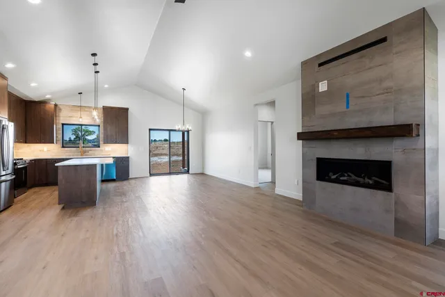 a open kitchen view with stainless steel appliances wooden floors and fireplace