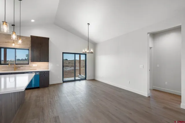 a view of large kitchen with granite countertop stainless steel appliances and wooden floor