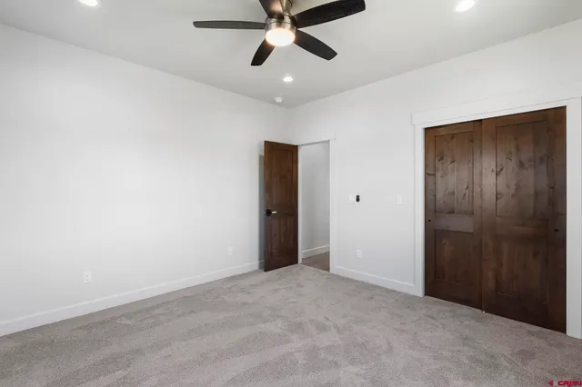 an empty room with closet and ceiling fan