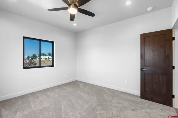 an empty room with window and ceiling fan