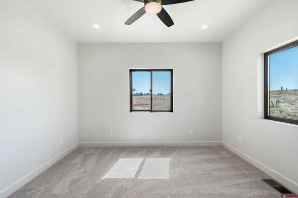 an empty room with a window and ceiling fan