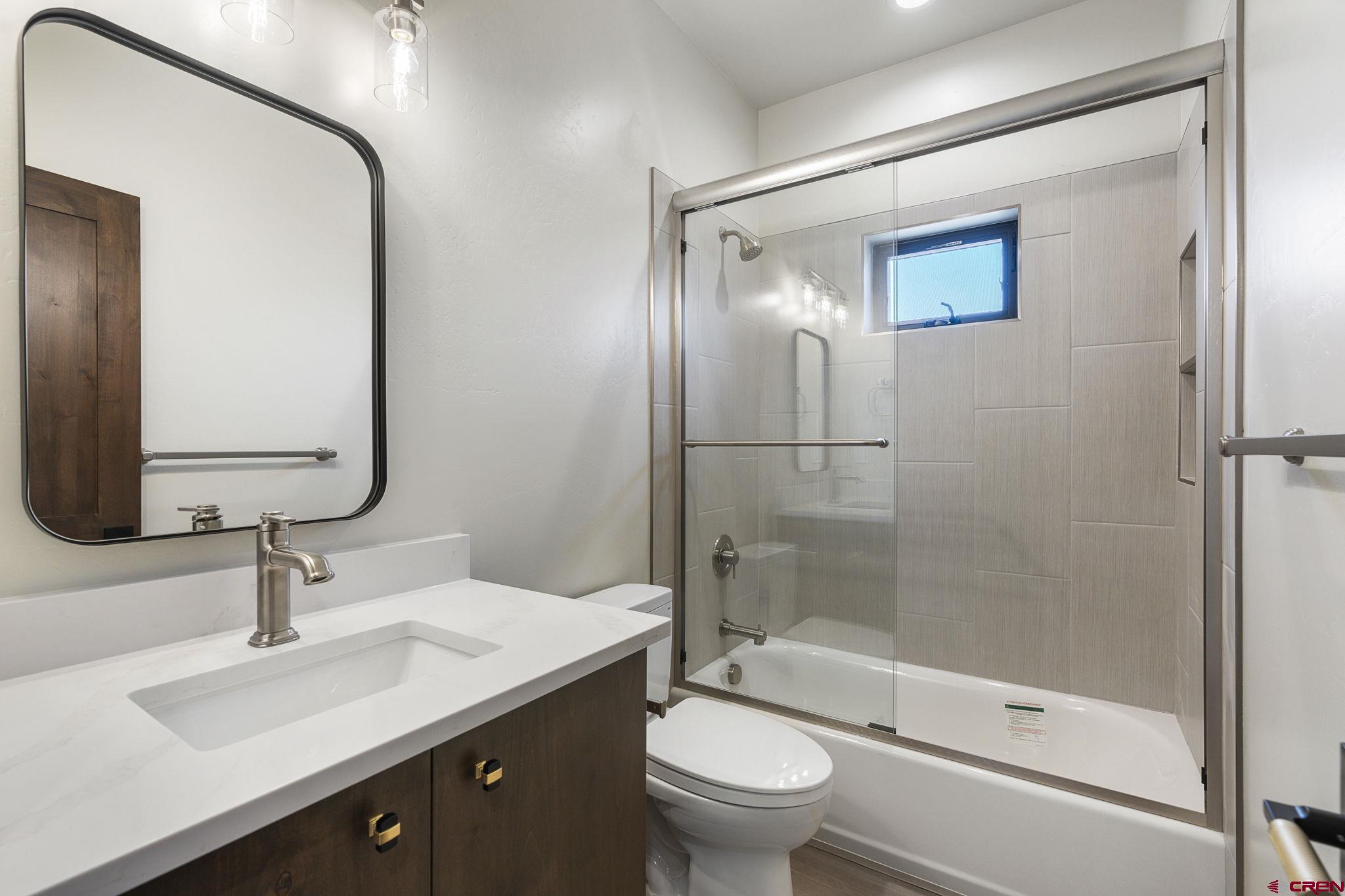 208 Petra Court Durango, CO 81303 - Photo 31 of 38 a bathroom with a double vanity sink toilet mirror and shower