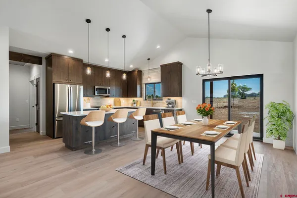 a view of a dining room and livingroom with furniture wooden floor a chandelier