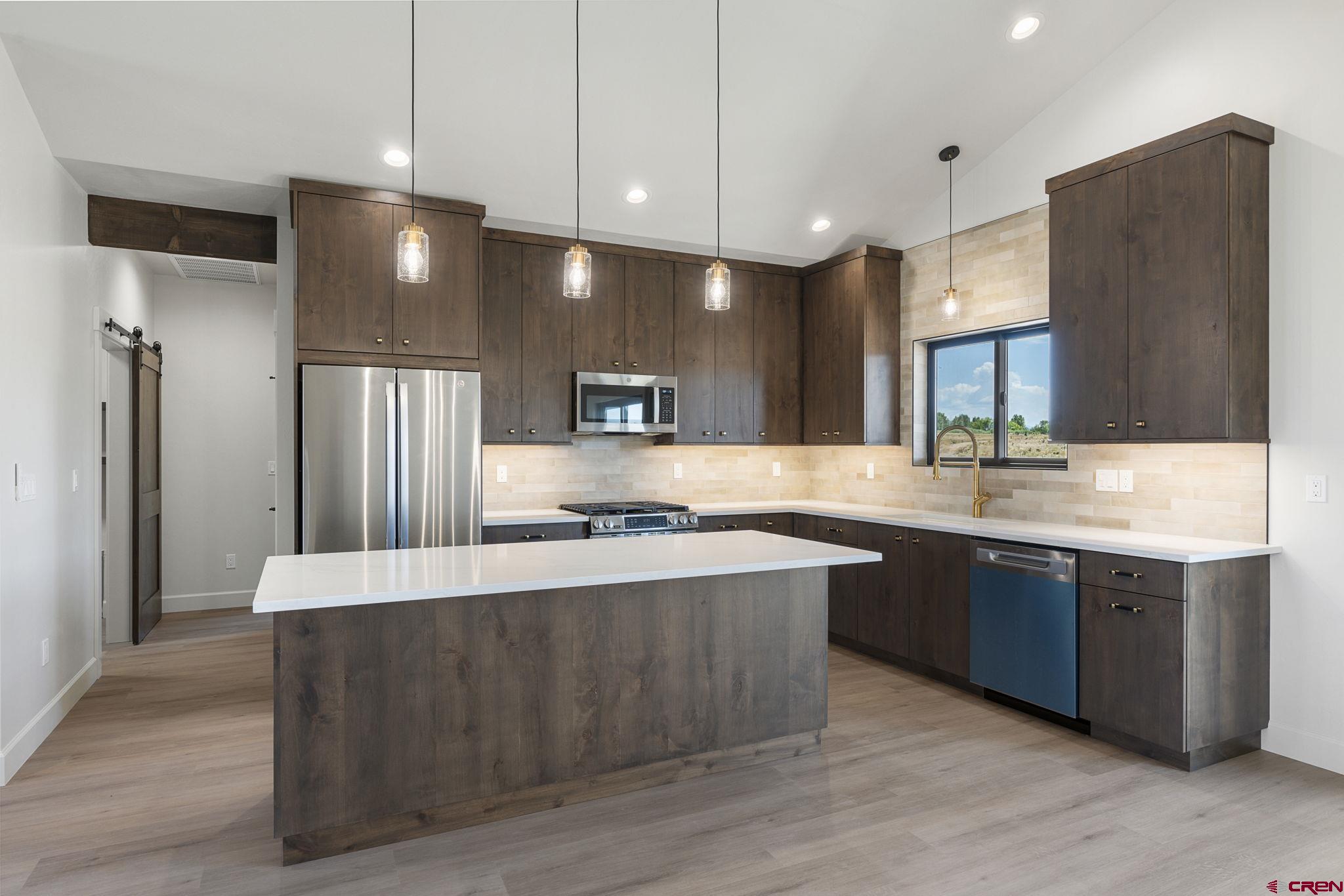 208 Petra Court Durango, CO 81303 - Photo 9 of 38 a large kitchen with stainless steel appliances a large counter top space and cabinets