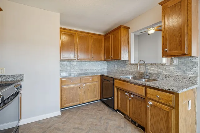 a kitchen with granite countertop cabinets sink and wooden floor