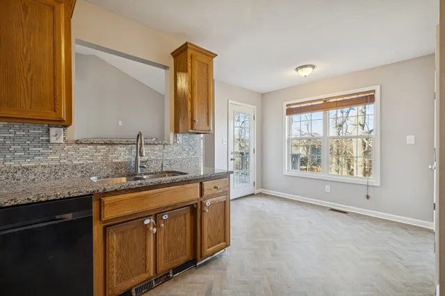 a kitchen with stainless steel appliances granite countertop a sink stove and cabinets