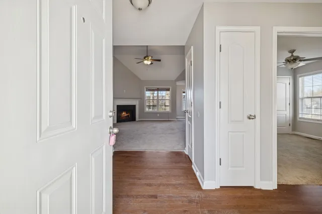 a view of a hallway with wooden floor and staircase