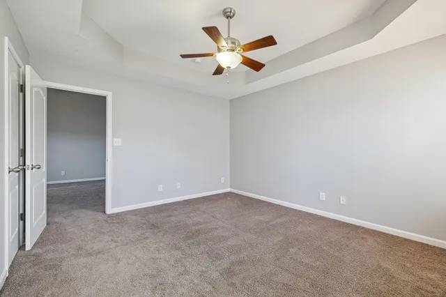 an empty room with closet and windows