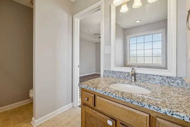 a bathroom with a granite countertop sink and a mirror