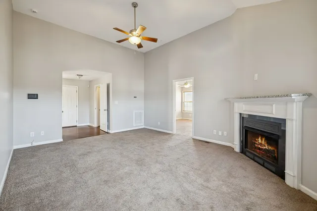 a view of empty room with fireplace and fan