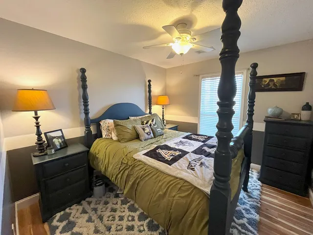 a bedroom with a bed and a lamp on dresser