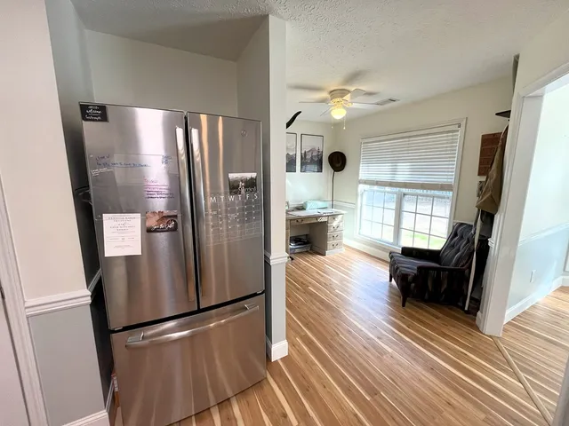 a kitchen with stainless steel appliances a refrigerator a table and chairs