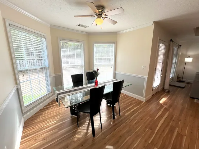 a view of a dining room with furniture window and wooden floor