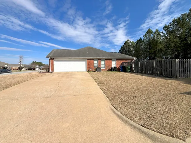 a view of house with yard and car parked
