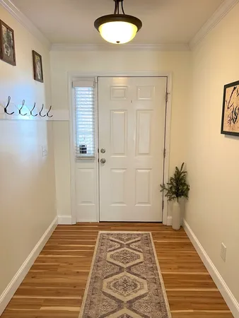 a view of a room with wooden floor and a chandelier