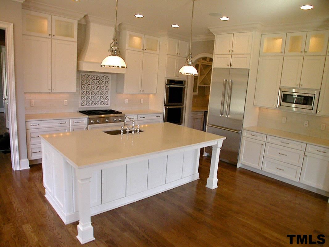 1005 Exeter Field Circle Raleigh, NC 27614 - Photo 14 of 25 a kitchen with stainless steel appliances granite countertop a table chairs and a refrigerator