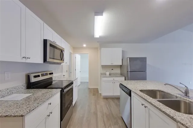 a kitchen with a sink stove top oven and refrigerator