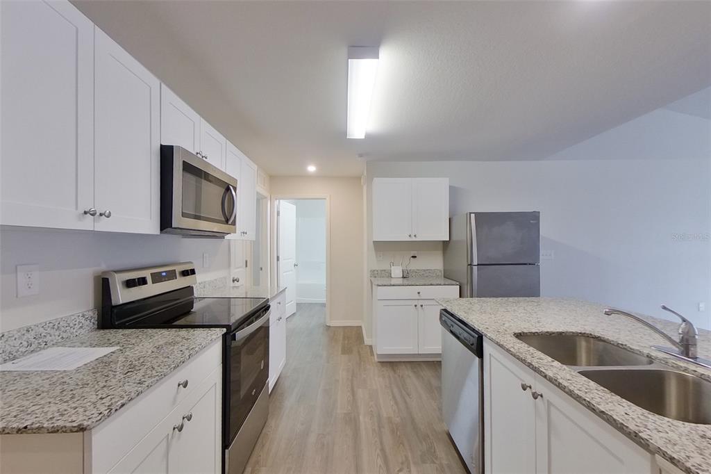 18318 Gibraltar Lane Lehigh Acres, FL 33936 - Photo 2 of 14 a kitchen with a sink stove top oven and refrigerator