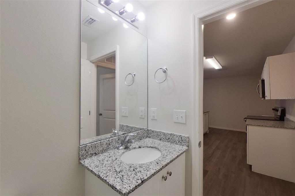 18318 Gibraltar Lane Lehigh Acres, FL 33936 - Photo 6 of 14 a bathroom with a granite countertop sink a mirror and a shower