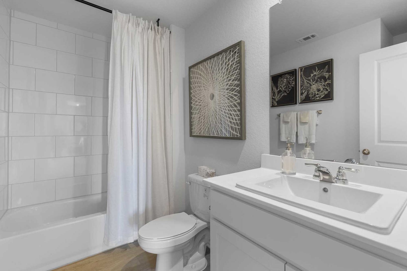 105 Hatari Trail Jarrell, TX 76537 - Photo 25 of 27 Crisp subway tile surrounds the built-in tub in this refreshed secondary bathroom.