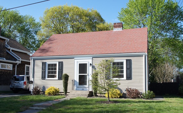 a backyard of a house with potted plants and large tree