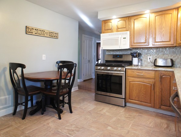 18 Vanness Road Weymouth, MA 02191 - Photo 3 of 19 a kitchen with a stove a table and chairs