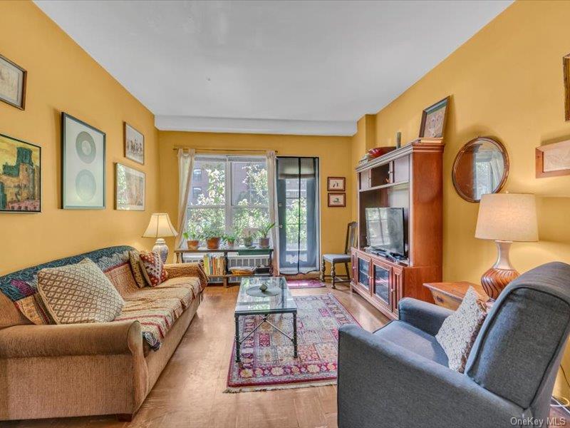 35-11 85th Street, Unit 1C Queens, NY 11372 - Photo 4 of 13 a living room with furniture and a large window