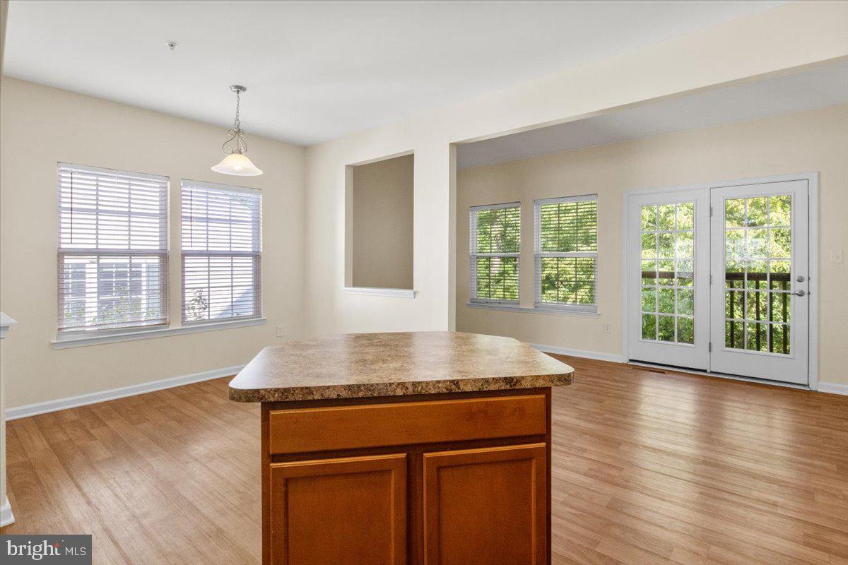 8329 Autumn Crest Lane, Unit 6 Chesapeake Beach, MD 20732 - Photo 12 of 30 a kitchen with kitchen island granite countertop a stove a sink and wooden floor