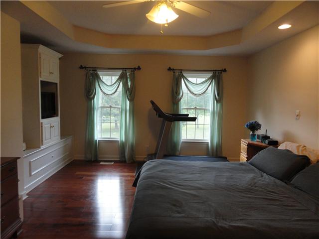 726 Vaughan Road Clarksville, TN 37043 - Photo 13 of 20 Huge main level master bedroom with built-in shelving, Brazilian hardwood floors, trey ceiling, ceiling fan and gorgeous windows with backyard view. Split bedroom plan is great for privacy.