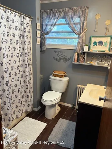 a bathroom with a toilet and a shower curtain