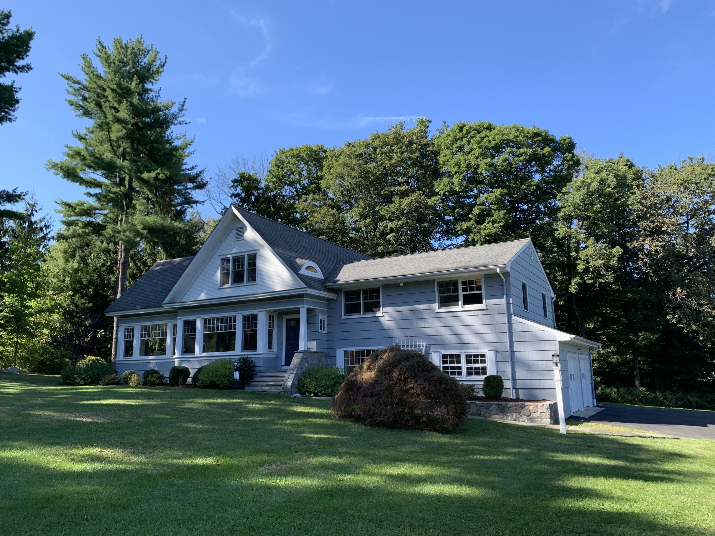 1335 Smith Ridge Road New Canaan, CT 06840 - Photo 1 of 42 a front view of a house with a garden and trees