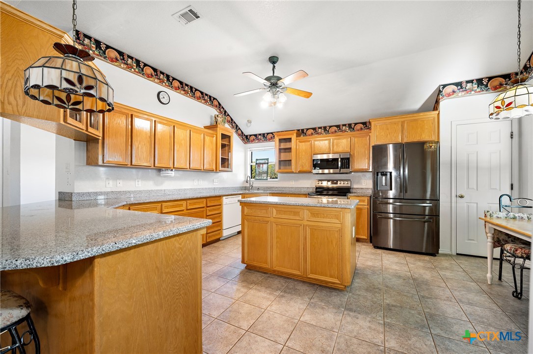 853 County Road 4390 Kempner, TX 76539 - Photo 31 of 43 a kitchen with stainless steel appliances granite countertop a sink a stove and a refrigerator