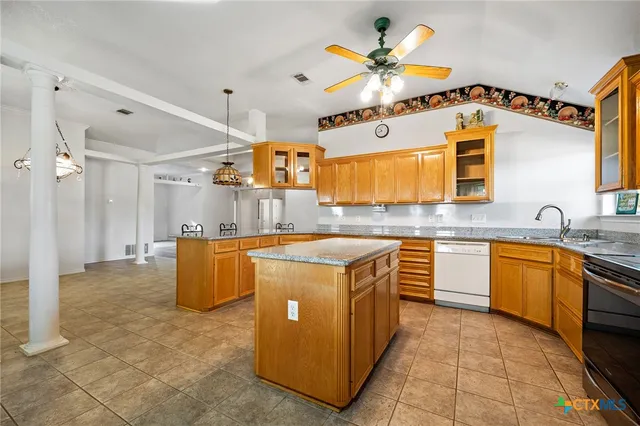 a kitchen with stainless steel appliances granite countertop a sink counter space cabinetry and a chandelier