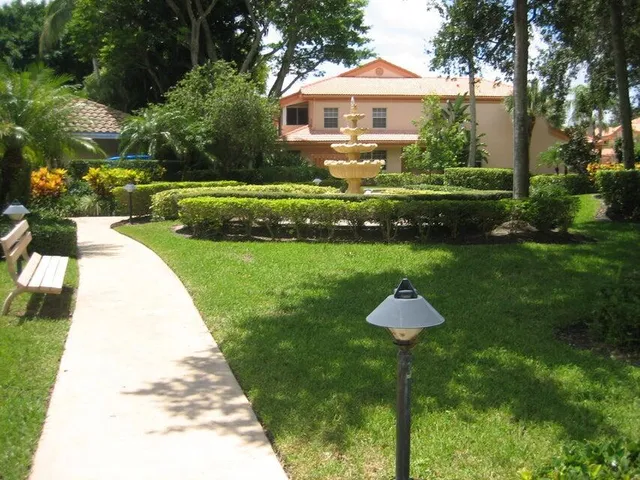 a front view of a house with a yard and fountain