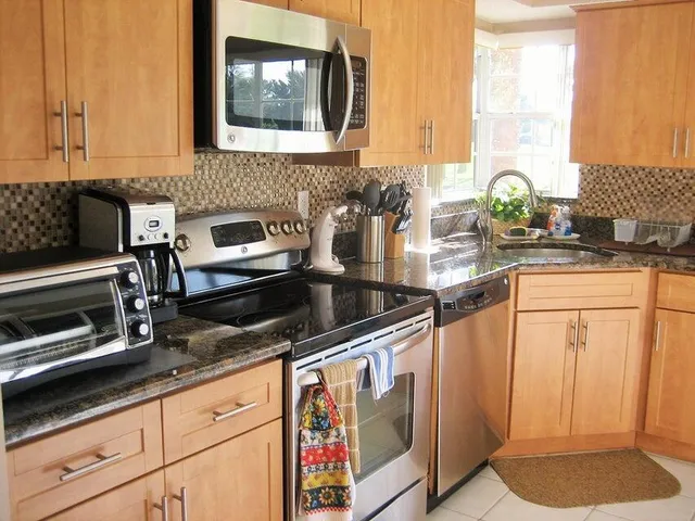 a kitchen with granite countertop a sink stove and cabinets