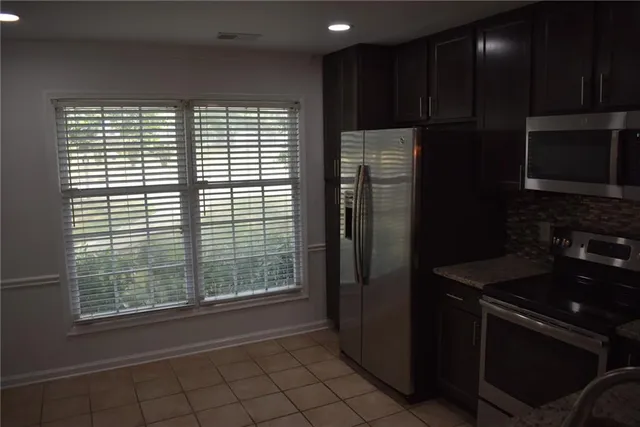 a kitchen with a refrigerator and a stove top oven