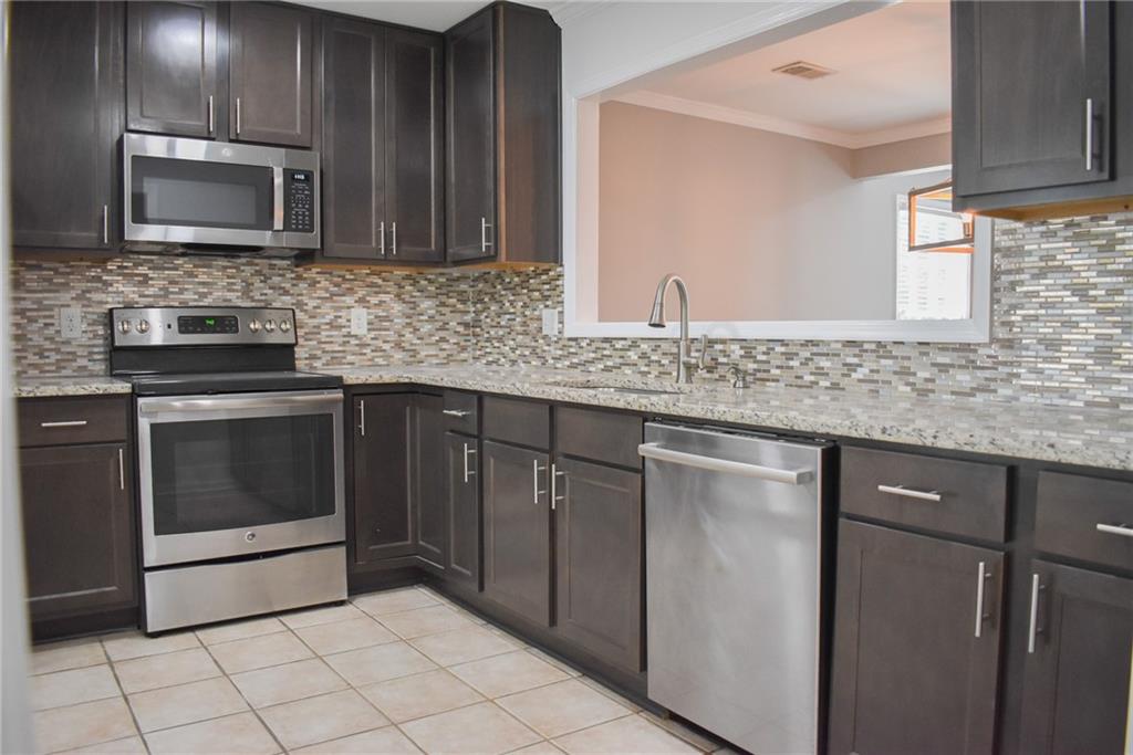 131 Willow Stream Court Roswell, GA 30076 - Photo 8 of 25 a kitchen with stainless steel appliances granite countertop a sink stove and microwave